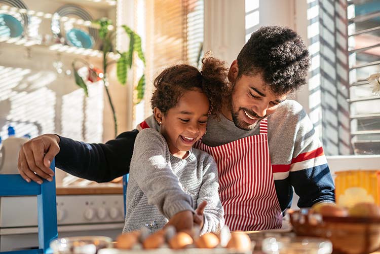 A father showing his daughter how to bake